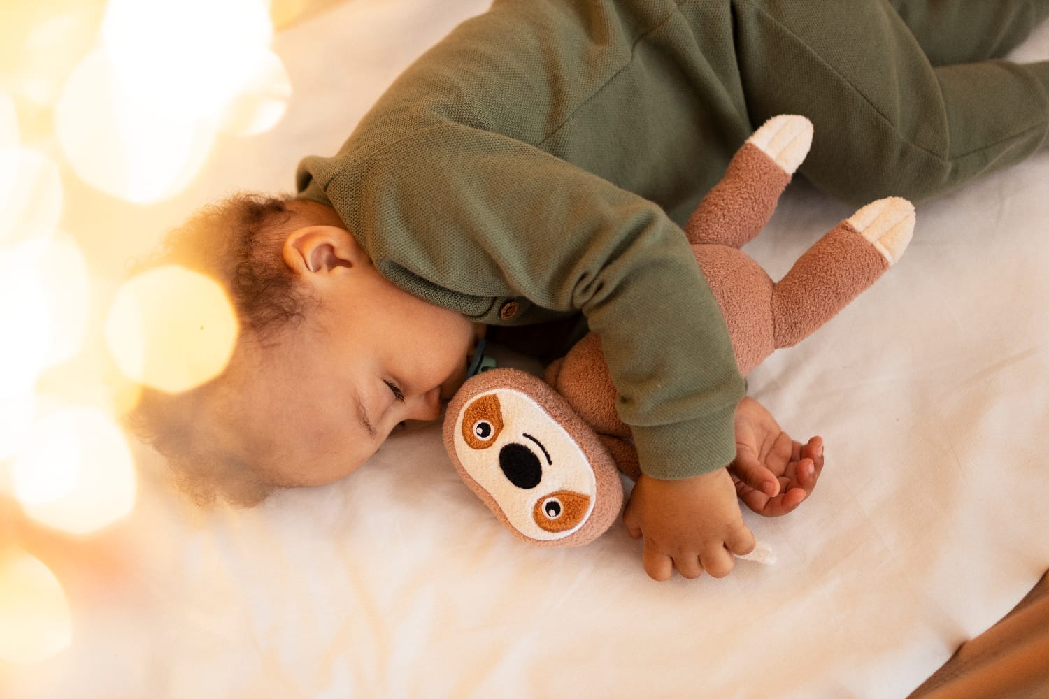 A baby peacefully hugging a plush toy during nap time, with Step By Step Nursery Dubai promoting healthy sleep routines for young children.