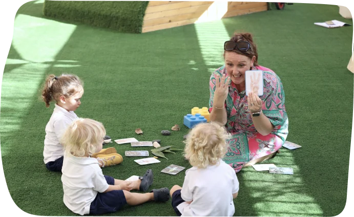 Nursery-aged children enjoying a maths activity outdoors with a teacher at Step By Step Nursery Dubai, enhancing numeracy through play.