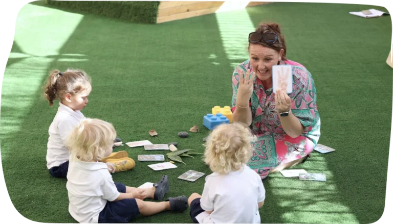 Nursery-aged children enjoying a maths activity outdoors with a teacher at Step By Step Nursery Dubai, enhancing numeracy through play.