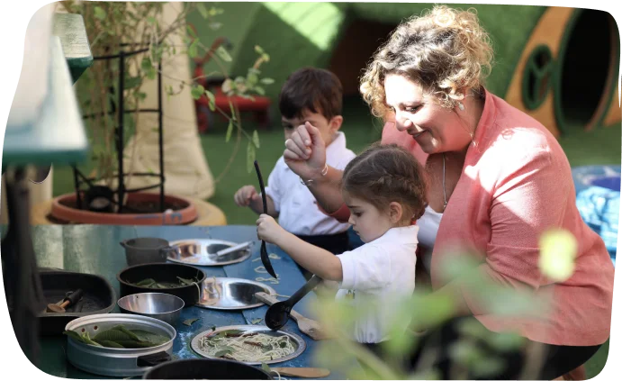 Toddlers participating in sensory exploration activities with a teacher at Step by Step Nursery Dubai, promoting hands-on learning.